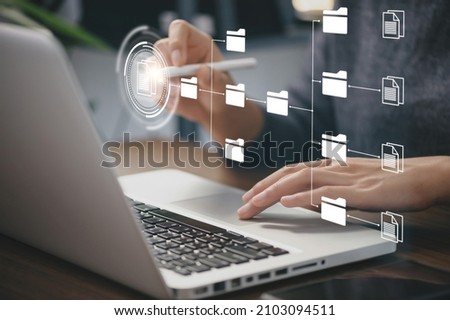 Businessman using a computer to document management concept, online documentation database and digital file storage system or software, records keeping, database technology, file access, doc sharing. Royalty-Free Stock Photo #2103094511