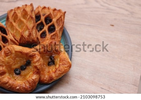Lattice Jam Tart served in a plate on a wooden table.