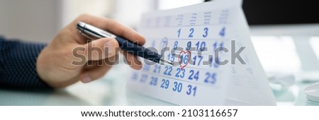 Calendar Deadline. Young Man Holding Pen Marking Date