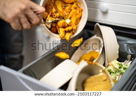 Throwing Away Leftover Food In Trash Or Garbage Dustbin Royalty-Free Stock Photo #2103117227