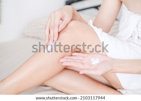 Woman applying cream,lotion on leg with white background, Beauty concept. Royalty-Free Stock Photo #2103117944