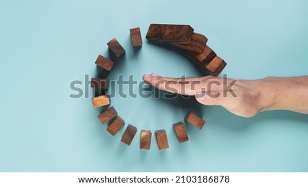 Top view and flat lay design of Businessman use gesture to stop wooden domino circle falling for insurance assurance and risk management concept. Royalty-Free Stock Photo #2103186878