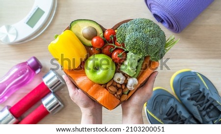 Healthy lifestyle on ketogenic diet, eating clean keto food good health dietary in heart dish with aerobic body exercise, gym workout training class , weight scale and sports shoes in fitness center Royalty-Free Stock Photo #2103200051