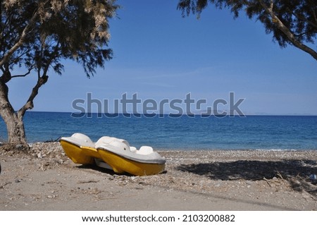A picture of the beach. Ready for a day on the water with a little yellow boat. 