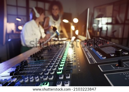Women working in modern radio studio, focus on professional mixing console