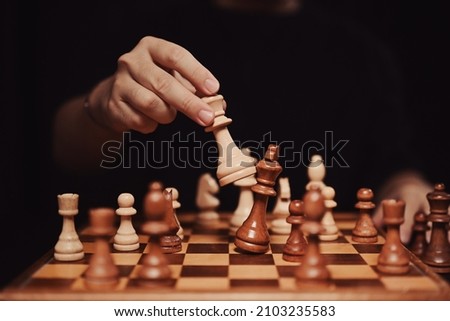 Successful business competition concept. Businessman moving chess piece and checkmate during competition. Royalty-Free Stock Photo #2103235583