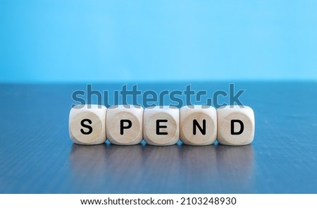 Spend the word on cubes on a background of old  background with cactus. Business concept.