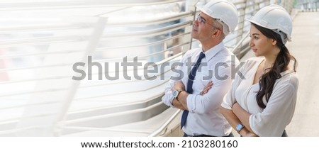 confident engineer man and business  woman standing and looking forward in construction site building outdoors . senior architect  meeting with female foreman crossed arms in city with copy space