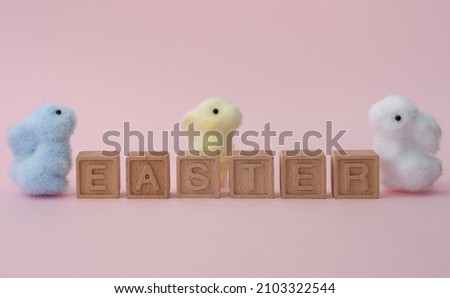 Happy Easter. The inscription happy easter. Three small bunny and cube toys.