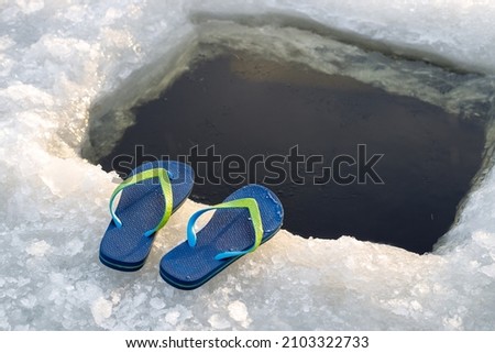 Ice hole and sneakers close-up. Hardening in cold water.
