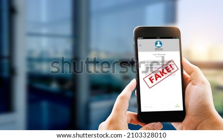 Fake Text message SMS scam or phishing concept. Man hands using smart phone Royalty-Free Stock Photo #2103328010