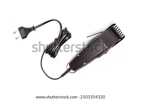 Professional hair clipper isolated on white background. Top view of the electric black hair clipper, closeup Royalty-Free Stock Photo #2103354320