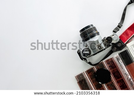Retro film camera with filmstrip on white background. Flat lay, Top view