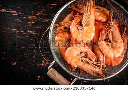 Fragrant boiled shrimp in a colander. On a rustic dark background. High quality photo