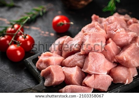 Chopped raw pork with fresh tomatoes and rosemary. Against a dark background. High quality photo