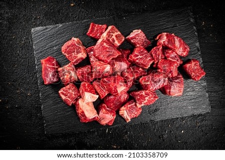 Pieces of raw beef on a stone board. On a black background. High quality photo Royalty-Free Stock Photo #2103358709