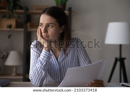 Frustrated upset young woman holding document with bad news. Disappointed student girl receiving paper letter from college, rejection notice from college, looking away, feeling sad, unhappy Royalty-Free Stock Photo #2103373418