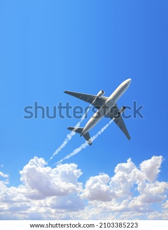 Vertical nature background with aircraft and Jet trailing smoke in the sky. Airplane and condensation trail. Foggy trail jet and plane in blue sky with white clouds. Traveling the world concept Royalty-Free Stock Photo #2103385223