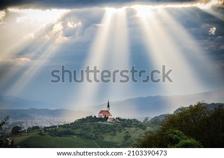 Sun rays shining down on a Church Royalty-Free Stock Photo #2103390473