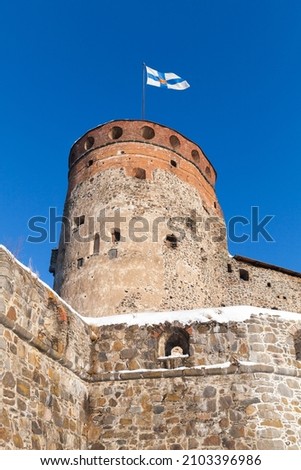 Olavinlinna is under blue sky, vertical photo. It is a 15th-century three-tower castle located in Savonlinna, Finland. The fortress was founded by Erik Axelsson Tott in 1475