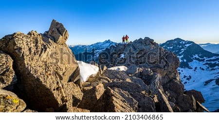 Hiking couple stands on the summit and looks towards Austria's highest mountain, Grossglockner, Tyrol, Austria, Europe Royalty-Free Stock Photo #2103406865