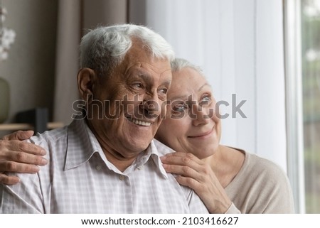 Head shot happy dreamy bonding old senior married couple of pensioners looking out of window in distance, thinking of pleasant life moments or recollecting good memories, ageing process concept. Royalty-Free Stock Photo #2103416627