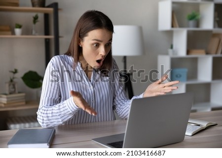 Stressed shocked computer user staring at laptop screen with open mouth in surprise, having problems with software, getting unexpected bad news, feeling stress about app or services errors Royalty-Free Stock Photo #2103416687