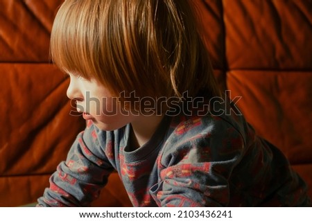 Young caucasian toddler boy child sitting in a chair with a laptop computer device indoor shot