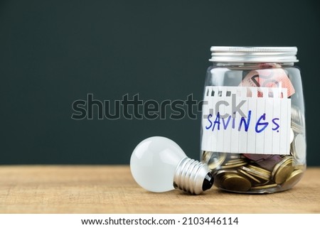 Savings money bottle with coins and light bulb as idea for saving concept