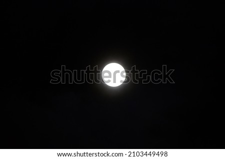 A picture of the moon in the middle of the sky. 