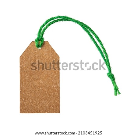 Empty cardboard tag  on a green flax twine isolated on white background. Blank brown paper label on a jute ribbon close-up. Copy space on recyclable rope tag of natural materials. Top view.