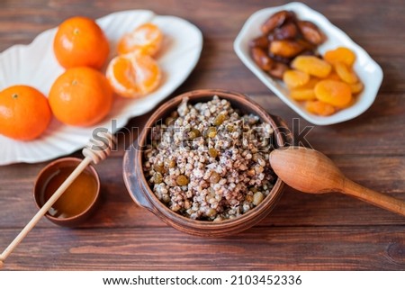 traditional dish kutya groats with fruits and raisins for christmas holiday for dinner with tangerines and honey