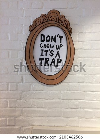 Peter Pan quote mirror design in front of a brick wall