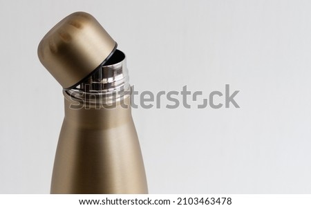 Open cap of metal thermos close-up on white background Royalty-Free Stock Photo #2103463478