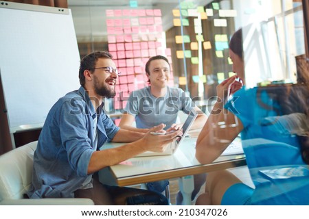 Young business partners sharing ideas and planning work at meeting in office Royalty-Free Stock Photo #210347026