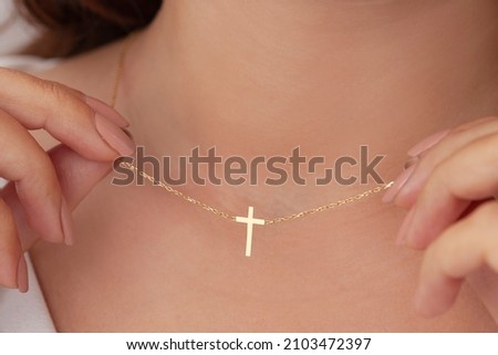 Attractive female model cross silver necklace. Woman wearing religious jewellery. Jewelry photo for e commerce, online sale, social media. Royalty-Free Stock Photo #2103472397