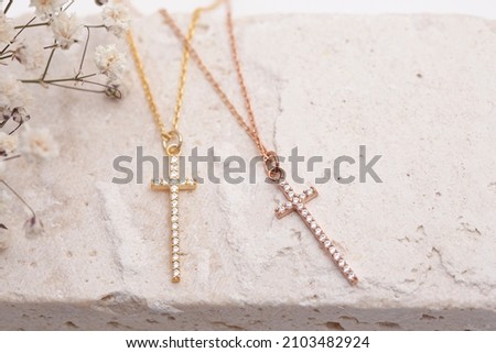 Silver cross necklace on the floor. Jewelry images that can be used in e-commerce, online sales and social media. Royalty-Free Stock Photo #2103482924