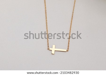 Silver cross necklace on the floor. Jewelry images that can be used in e-commerce, online sales and social media.
