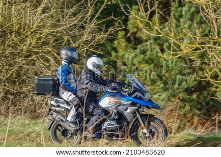 motorbike rider and pillion passenger on a BMW R1200 GS motorcycle travelling through winter countryside Royalty-Free Stock Photo #2103483620