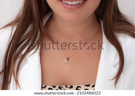 Initial necklace on the woman's neck. Jewelry images that can be used in e-commerce, online sales and social media.