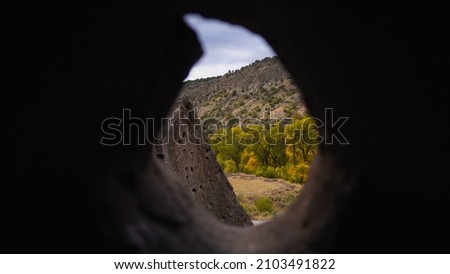 Scenic mountain view through hole in rocks
