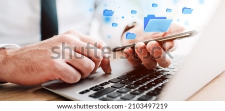 Document management system (DMS) concept, businessman using laptop and smartphone in office work, digitally enhanced image with selective focus
