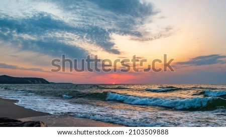 The last moments of the sunset in the wavy sea