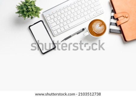 Office desk with computer, Blank screen smart phone, Notebook, pen, Cup of coffee on blue background, Top view with copy space, Mock up..