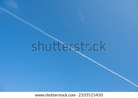 The plane's wake across the sky is like a cloud