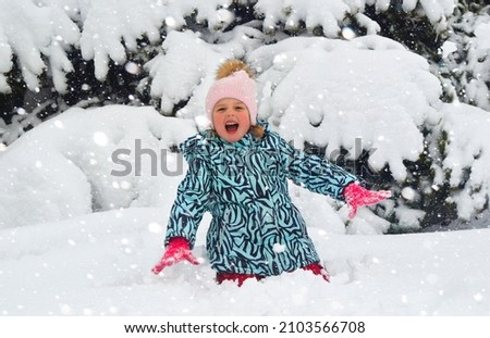 caucasian child in winter clothing playing outdoors.