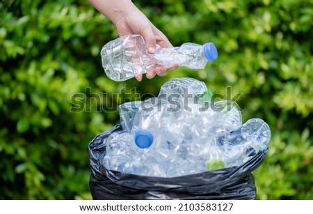 Plastic bottles in black garbage bags waiting to be taken to recycle. Royalty-Free Stock Photo #2103583127