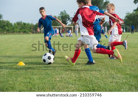boys kicking football on the sports field Royalty-Free Stock Photo #210359746