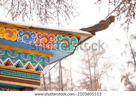 The roof of the Buddhist monastery is a traditional Tibest ornament on wood Buryat religion Royalty-Free Stock Photo #2103605513