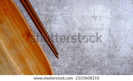 Wooden Chopsticks and wooden bowl on the table. Wooden kitchenware that gives a classic and minimalist impression. Food and drink concept. Food Photography. Flat Lay, Top View. High Angle view.